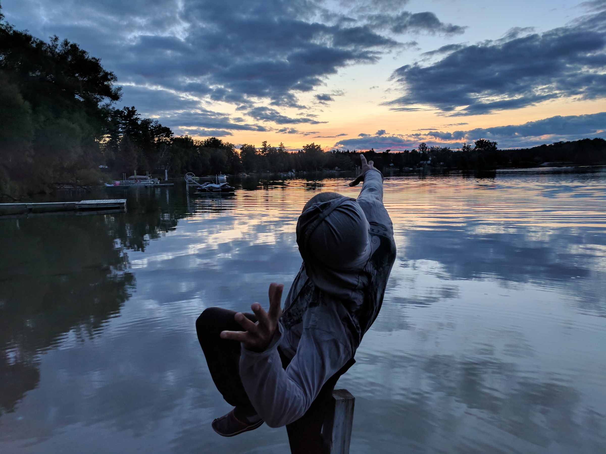 Ali Sardar reaching out over still water at dusk